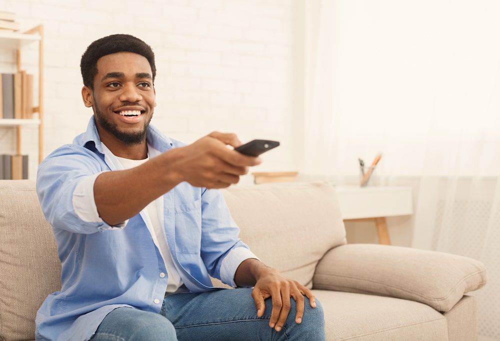 man watching tv with a remote in hand