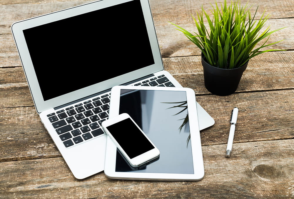 a phone, tablet, and computer sitting on a desk